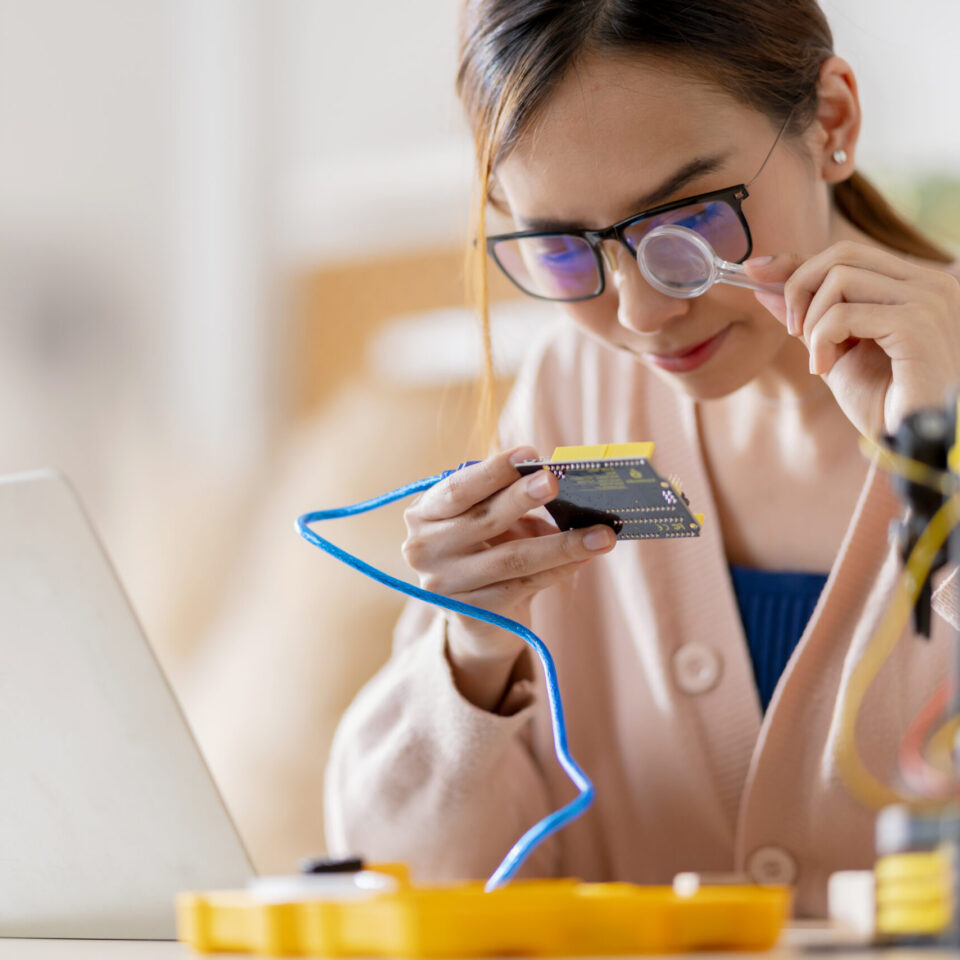 smart-asian-female-programer-learning-robot-arm-ai-coding-electronic-board-cable-stem-steam-she-try-testing-her-autonomous-robotic-arm-with-sensors-via-arduino-platform-home